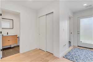 Bedroom with a closet, light hardwood / wood-style flooring, and sink