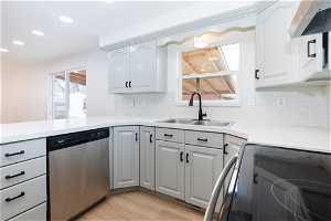 Kitchen with sink, light hardwood / wood-style floors, range, premium range hood, and dishwasher