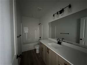 Full bathroom with wood-type flooring, shower / bath combination, toilet, and large vanity