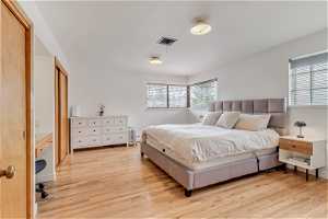 Primary ensuite bedroom featuring light hardwood floors