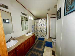 Bathroom with double sink, tile floors, crown molding, large vanity, and toilet