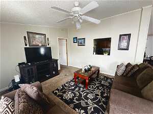 Living room featuring dark carpet, a textured ceiling, and ceiling fan