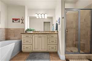 Bathroom featuring crown molding, shower with separate bathtub, tile floors, and vanity