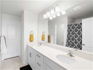 Bathroom featuring tile flooring, dual sinks, and large vanity