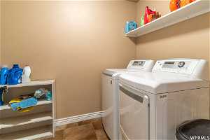 Main Laundry room featuring washer and dryer and dark tile flooring