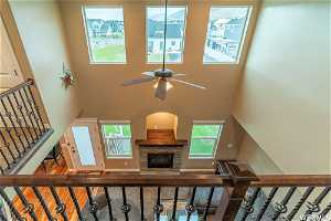 Staircase Balcony looking down to fireplace, ceiling fan, wood-type flooring, Vaulted ciellings