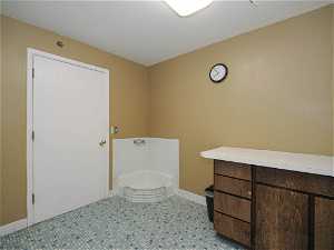 Bathroom featuring tile floors, vanity, and a washtub