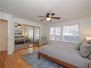 Bedroom featuring crown molding, multiple windows, ceiling fan, and light wood-type flooring