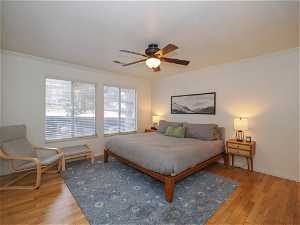 Bedroom featuring light hardwood / wood-style floors, ceiling fan, and crown molding