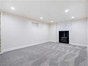Unfurnished living room with carpet flooring and a large fireplace