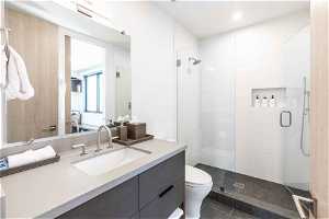 Bathroom featuring toilet, tile flooring, an enclosed shower, and vanity