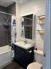 Full bathroom featuring shower / bath combination with curtain, large vanity, and toilet