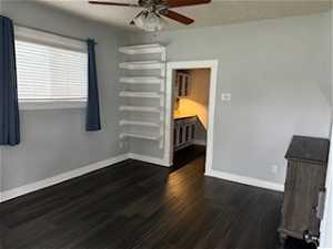 Unfurnished bedroom featuring dark hardwood / wood-style floors and ceiling fan
