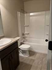 Full bathroom with shower / washtub combination, large vanity, tile flooring, and toilet