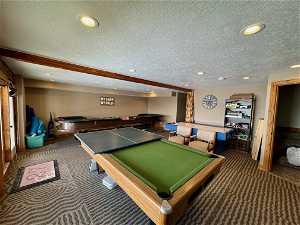 Game room with dark carpet, pool table, and a textured ceiling