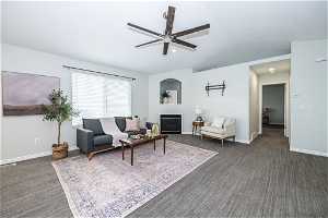 Living room featuring dark carpet and ceiling fan