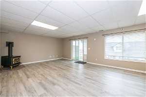 Unfurnished room with a paneled ceiling, gas stove, and light hardwood / wood-style flooring