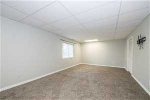 Spare room featuring carpet floors and a drop ceiling