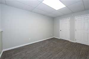 Interior space with a drop ceiling and dark colored carpet