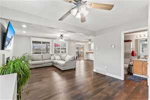 Family room with a healthy amount of sunlight, ceiling fan, and dark hardwood / wood-style floors