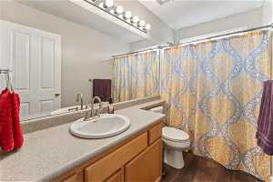 Upstairs Bathroom with toilet, large vanity, and hardwood / wood-style flooring
