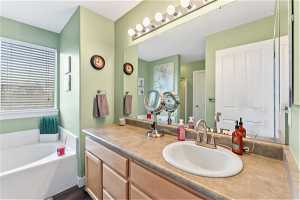 Master Bathroom with tiled tub and vanity with extensive cabinet space