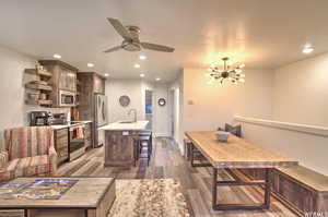 Interior space with dark wood-type flooring, sink, and ceiling fan with notable chandelier