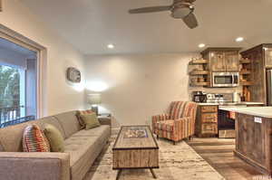 Living room with dark hardwood / wood-style flooring and ceiling fan