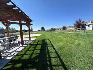 View of yard with a pergola and a patio