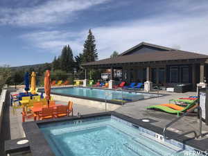 View of swimming pool featuring an outdoor hangout area, a hot tub, and a patio area