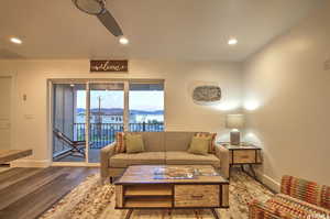 Living room with dark hardwood / wood-style floors and ceiling fan