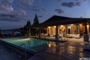 Pool at dusk featuring an outdoor hangout area and a patio area