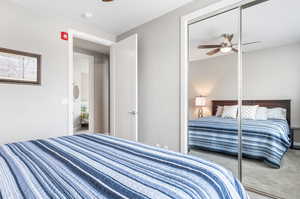 Bedroom featuring a closet, ceiling fan, and carpet