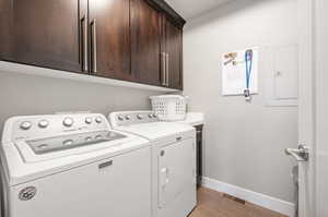 Laundry room featuring light tile floors, cabinets, and washing machine and dryer