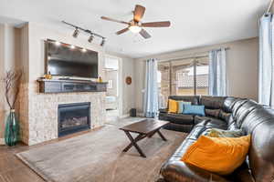 Living room with ceiling fan, and a stone fireplace