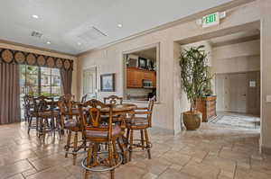 Tiled dining space with a textured ceiling and vaulted ceiling