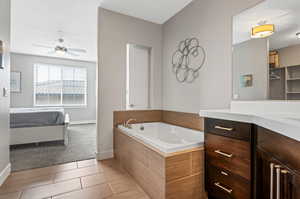 Primary ensuite featuring a relaxing soaker tub, walk in closet, and separate shower.