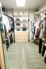 Master spacious walk in closet with carpet flooring