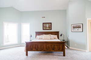 Master Carpeted bedroom featuring lofted ceiling