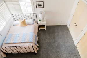 Carpeted bedroom featuring multiple windows