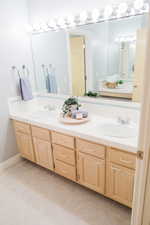 Upstairs bathroom with dual bowl vanity and tile floors