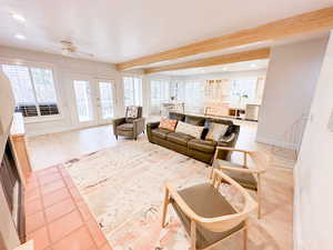 Living room with light LVP floors, ceiling fan, fireplace and a wealth of natural light