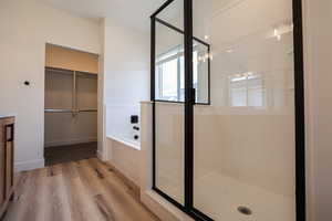 Bathroom with independent shower and bath, vanity, and hardwood / wood-style flooring