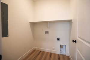 Clothes washing area featuring electric panel, hookup for a gas dryer, hardwood / wood-style flooring, hookup for a washing machine, and electric dryer hookup