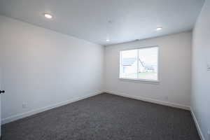 Primary Bedroom with dark colored carpet