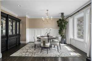 Dining area with crown molding, an inviting chandelier, and dark hardwood / wood-style flooring