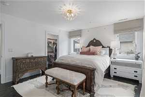 Bedroom with an inviting chandelier, a spacious closet, a closet, and dark hardwood / wood-style flooring