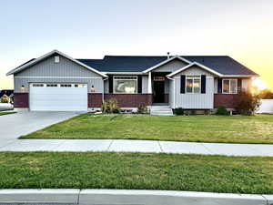 View of front of house with a garage and a lawn