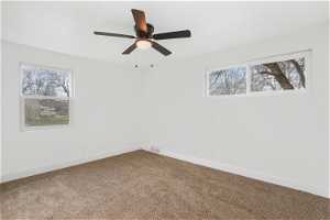 Bedroom with a healthy amount of sunlight, carpet flooring, and ceiling fan