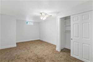 Bedroom with light colored carpet, a closet, and ceiling fan